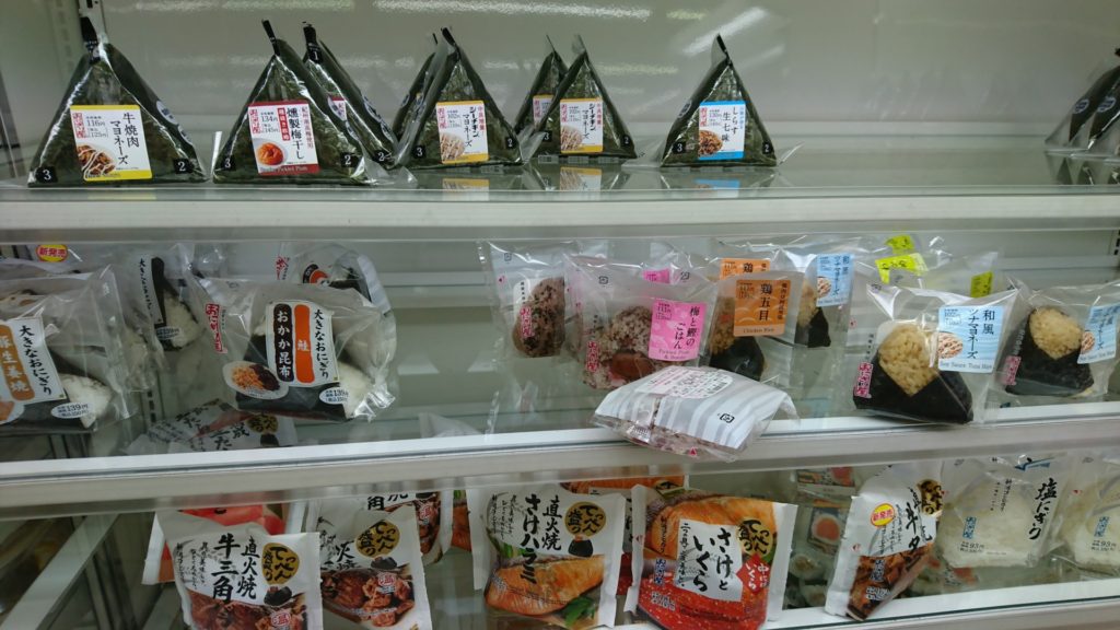 Olika typer av onigiris till försäljning i en convenience store